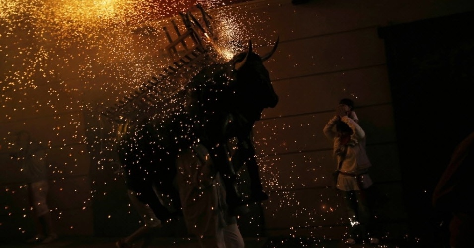 10.jul.2012- Foliões tentam fugir e faísca de fogos de artifícios durante celebrações do festival de São Firmino em Pamplona, na Espanha