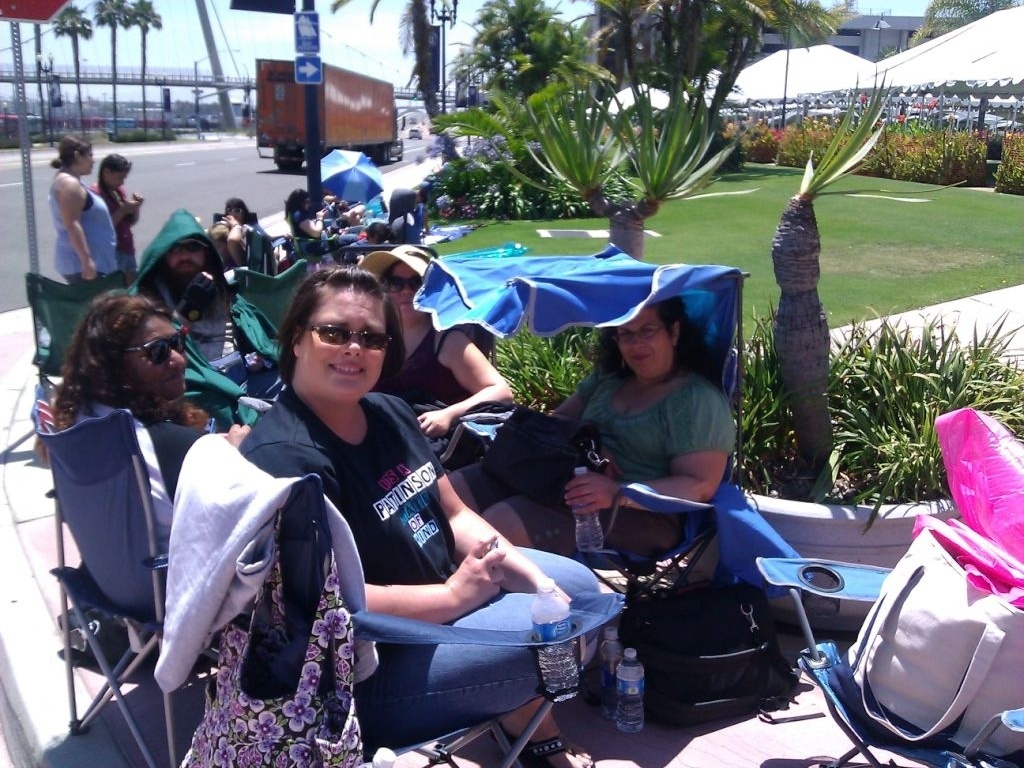 A imagem, postada no Twitter, mostra Giselle G. (de top verde, na cadeira com cobertura azul) na fila para entrar no Centro de Conveções de San Diego - Reprodução