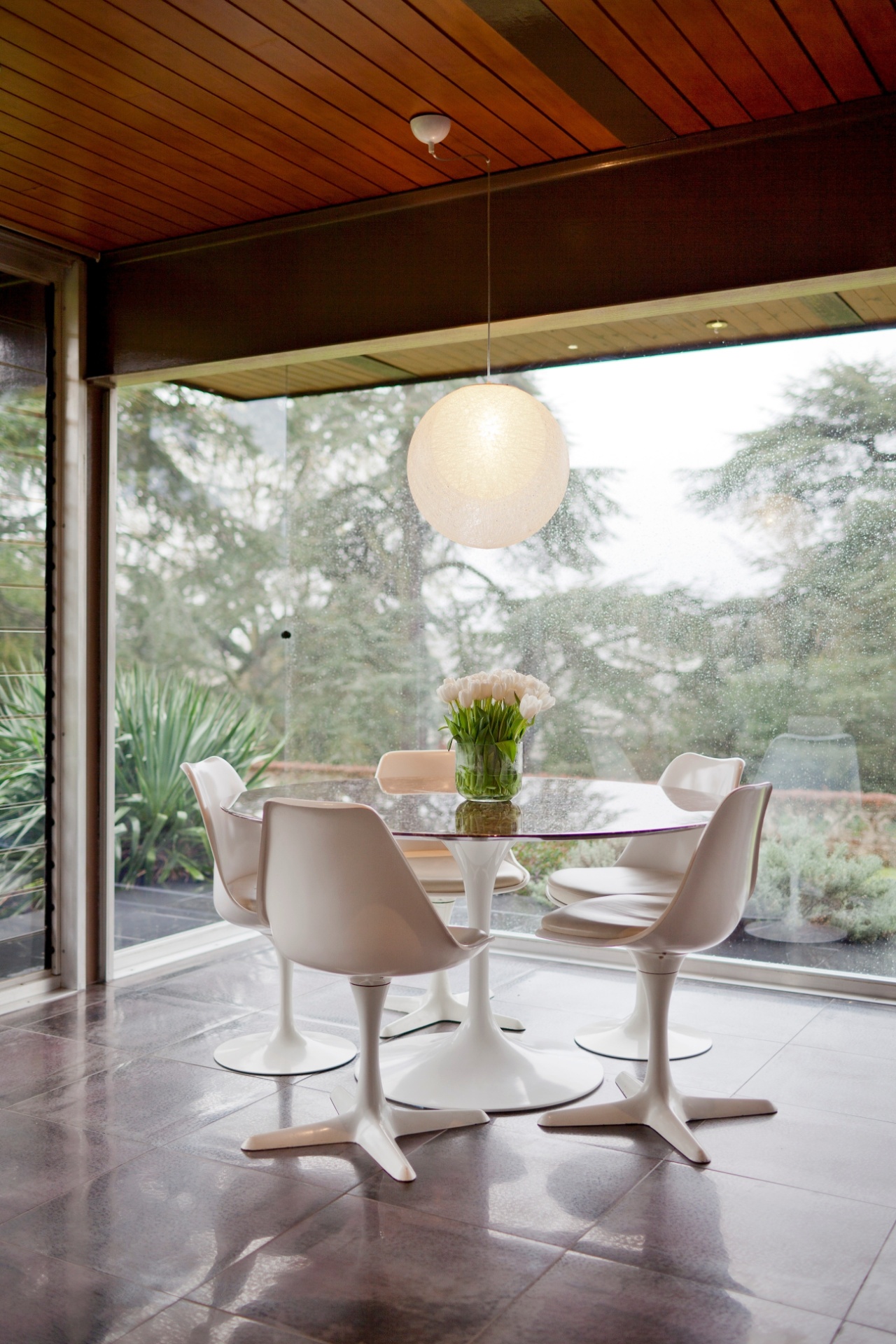 A sala de jantar da casa de Remy Blumenfeld e Henryk Hetflaisz, conhecida como Solar do Cavalo, em Horsmonden, na Inglaterra. Destaque para a mesa e as cadeiras Tulipa de Eero Saarinen e a luminária de náilon Yamagiwa, do arquiteto japonês Toyo Ito - Andreas Meichsner/ The New York Times