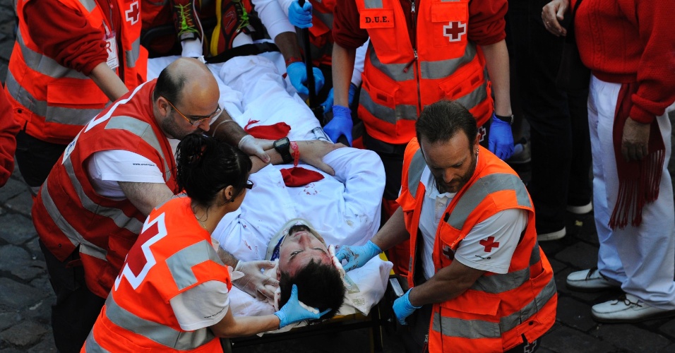 12.jul.2012 - Homem é removido do local onde caiu para receber assistência médica, durante o sexto dia de corrida com os touros na Festa de São Firmino, em Pamplona, na Espanha