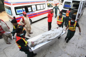 Equipes de resgate carregam corpo de policial morto em ataque no Paquistão, nesta quinta-feira (12)