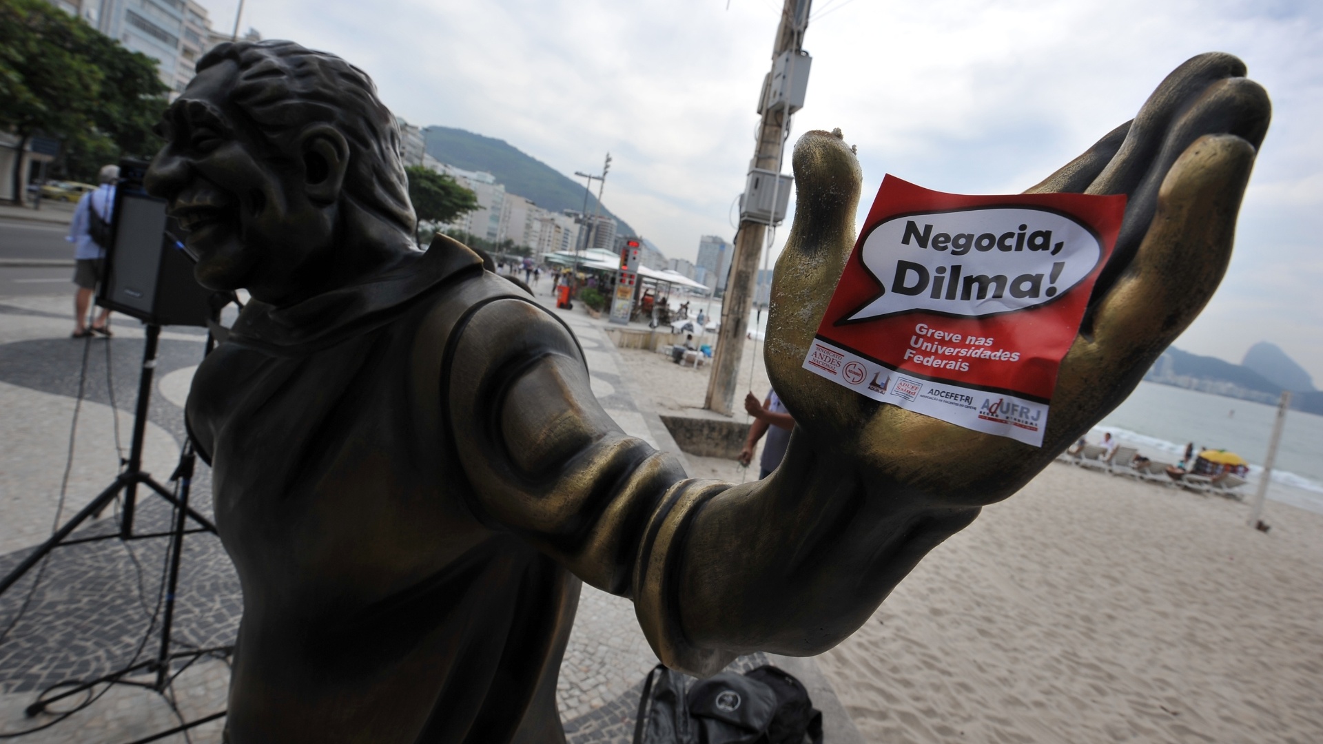 12.jul.2012 - Já no calçadão da praia de Copacabana, os manifestantes usaram a estátua do compositor Dorival Caymmi (1914-2008) para protestar e pedir que a presidente Dilma Rousseff entre na negociação com os professores e servidores em greve - André Lobo/UOL