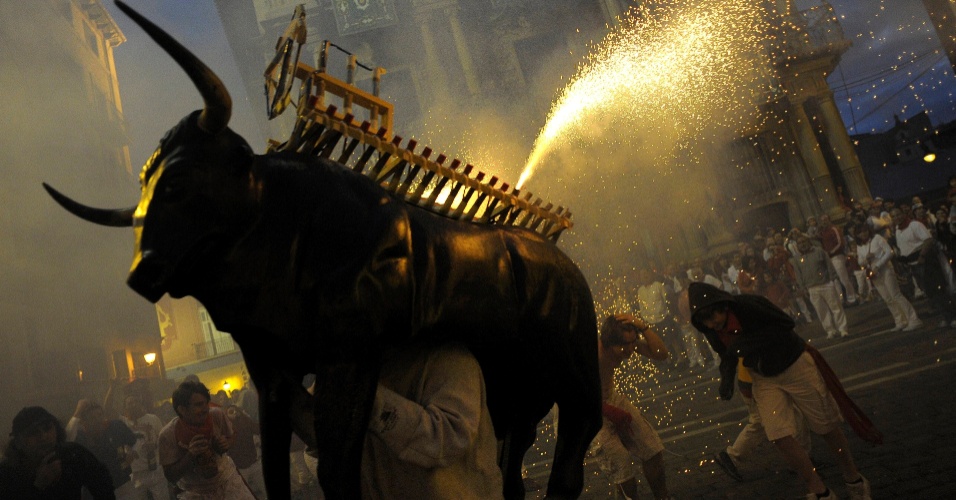 12.jul.2012 - O conhecido touro de madeira que solta fogos desfila nas ruas do centro de Pamplona, na Espanha, na noite de quarta-feira (11). É parte das comemorações da tradicional Festa de São Firmino