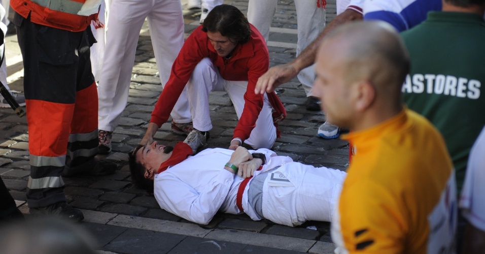 12.jul.2012 - Rapaz machucado recebe os primeiros socorros na rua, durante o sexto dia da Festa de São Firmino, em Pamplona, na Espanha