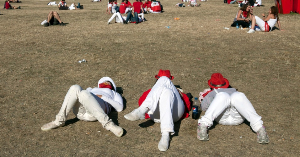 12.jul.2012 - Três moças descansam na manhã desta quinta-feira (12), depois de mais uma noite de festa no Festival de São Firmino, em Pamplona, na Espanha