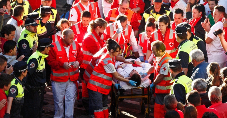 12.jul.2012 - Tropas da Cruz Vermelha levam norte-americano ferido ao hospital de Navarra, após ele sofrer um traumatismo craniano na Festa de São Firmino, em que touros são soltos na rua e correm atrás dos participantes em Pamplona, na Espanha