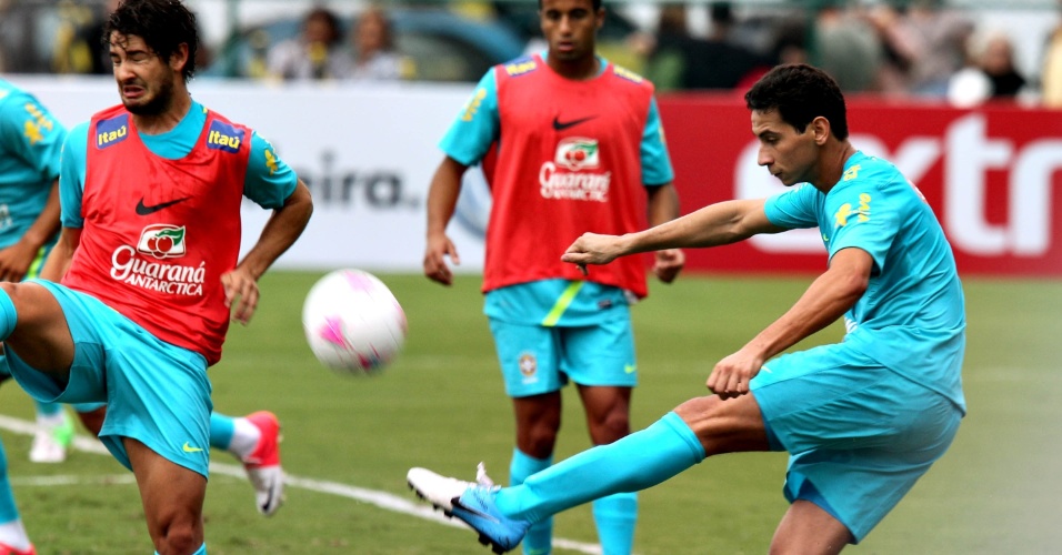Ganso finaliza e Pato tenta bloqueio em coletivo no treino da seleção no Rio de Janeiro