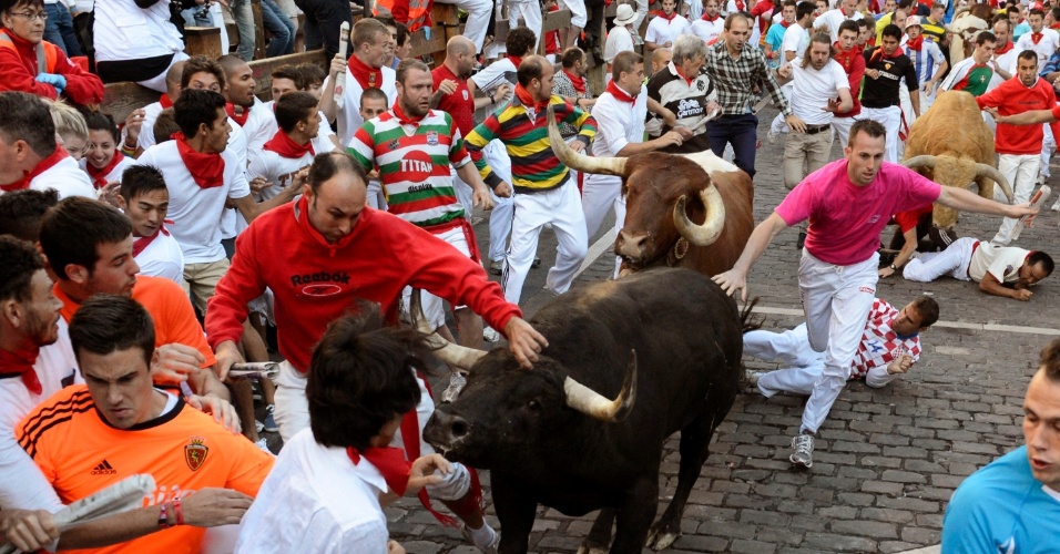 13.jul.2012 - Turistas fogem de touros durante a Festa de São Firmino em Pamplona, na Espanha, nesta sexta-feira (13)