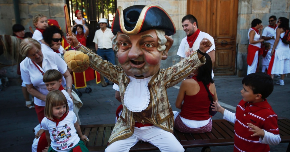 13.jul.2012- Crianças brincam com o bonecão durante a Parada das Cabeças Gigantes, que é parte das comemorações do Festival de São Firmino, em Pamplona, na Espanha