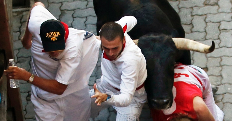 13.jul.2012- Foliões correm do touro nesta sexta-feira (13) nas ruas do centro de Pamplona, na Espanha, durante a Festa de São Firmino
