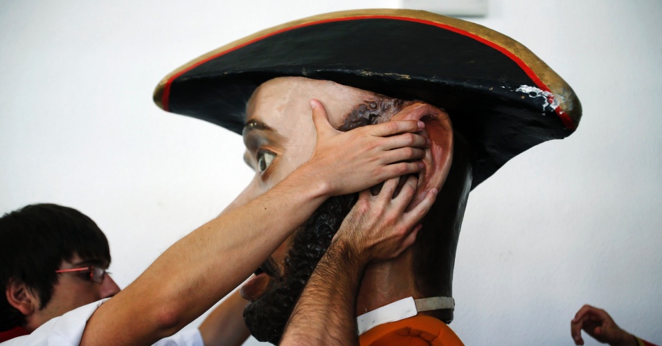 13.jul.2012- O "kiliki", bonecão de rua típico da festa, consegue ajuda para tirar a máscara depois da Parada das Cabeças Gigantes, que é parte das comemorações do Festival de São Firmino, em Pamplona, na Espanha