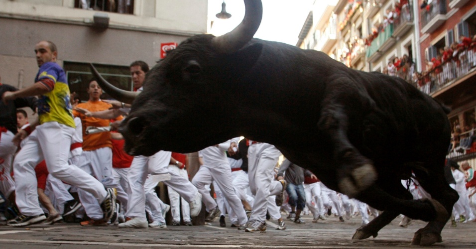 13.jul.2012-Touro dá uma canseira nos foliões nas ruas do centro de Pamplona, na Espanha, durante a Festa de São Firmino