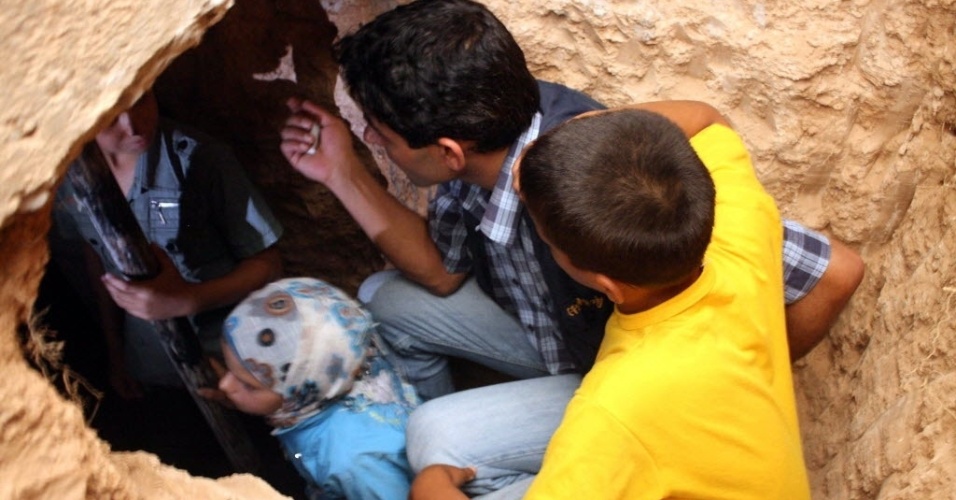 15.jul.2012 - Sírios são acomodados em abrigo improvisado embaixo de um comércio de Qusayr, (Homs)