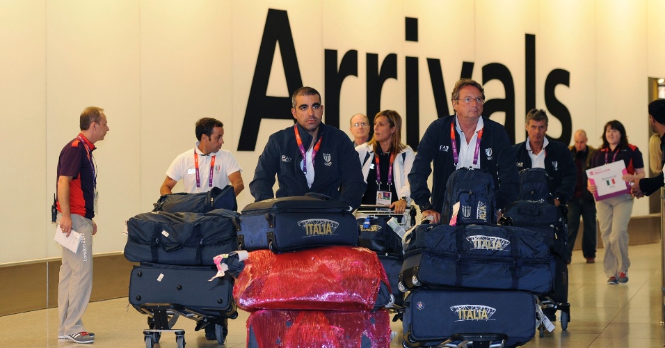 Membros da delegação italiana desembarcam no aeroporto de Heathrow, na primeira leva de atletas a chegar aos Jogos