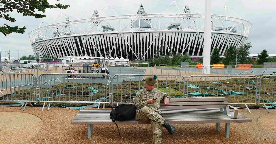Soldado britânico descansa sentado em banco próximo ao estádio olímpico em Stratford