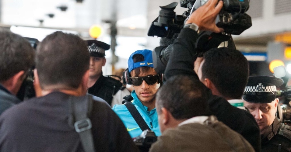 Neymar chega ao aeroporto de Heathrow, em Londres, e é cercado por jornalistas e seguranças