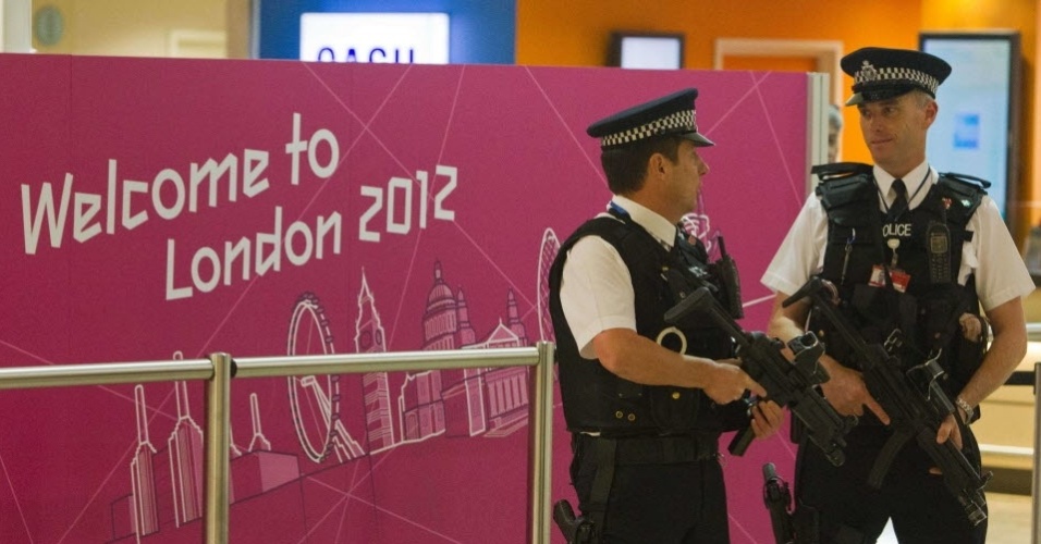 Policiais britânicos fazem a segurança na área de desembarque dos atletas no aeroporto de Heathrow