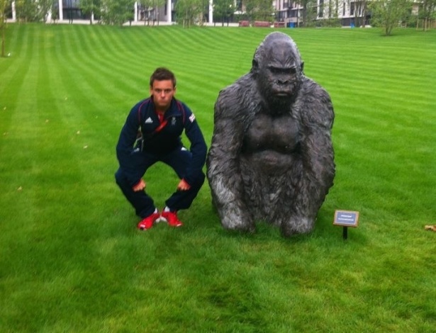 Saltador britânico Tom Daley imita uma estátua de gorila, que está dentro da Vila Olímpica