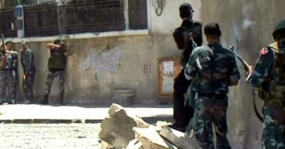 18.jul.2012 - Reprodução da TV Síria mostra forças de segurança locais atuando nesta quarta-feira (18) durante confronto armado com atiradores que a TV chama de "terroristas" no distrito de Al-Midan, na capital Damasco