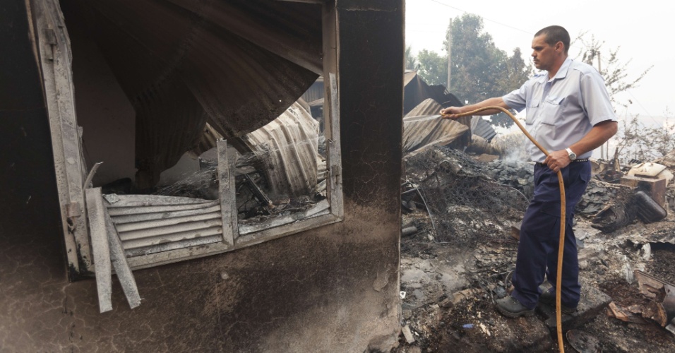 19.jul.2012 - Bombeiros trabalham no controle de incêndio florestal nesta quinta-feira (19), que pode atingir casas do vilarejo de Camacha, nas montanhas da cidade de Funchal, na ilha portuguesa da Madeira