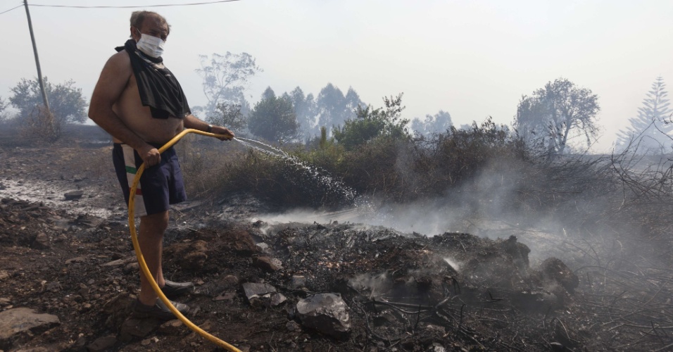 19.jul.2012 - Bombeiros trabalham no controle de incêndio florestal nesta quinta-feira (19), que pode atingir casas do vilarejo de Camacha, nas montanhas da cidade de Funchal, na ilha portuguesa da Madeira