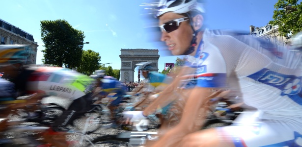 Ciclista passa em frente ao Arco do Triunfo durante último dia da Volta da França em Paris - AFP PHOTO / JEFF PACHOUD