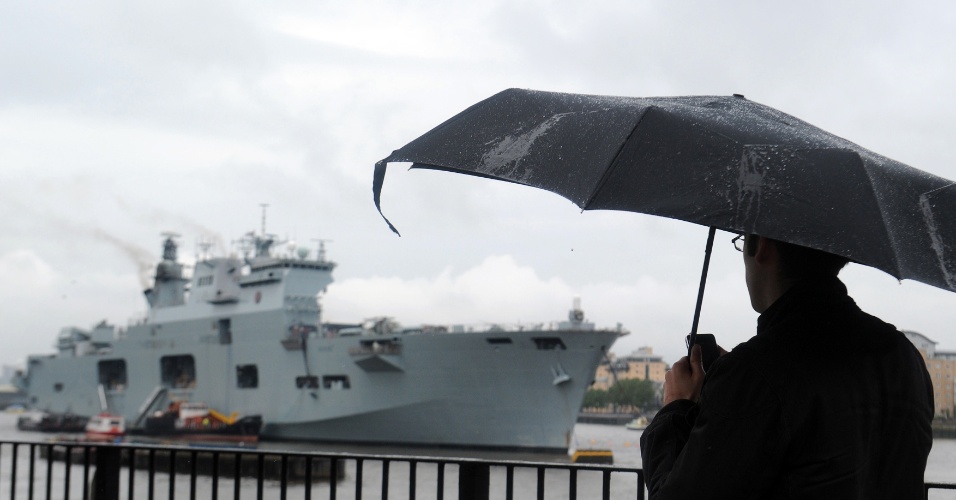 Homem observa o navio HMS Ocean, que fará a segurança naval durante os Jogos Olímpicos de Londres