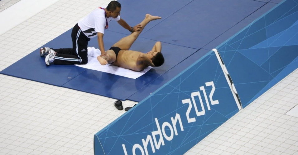 Médico Juan Antonio Avila Gordillo alonga o mergulhador mexicano Yahel Castillo em treino para a Olimpíada de Londres (23/07/2012)
