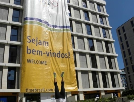 Saltadora Juliana Veloso "planta bananeira" em frente a prédio aonde vão ficar atletas brasileiros nos Jogos Olímpicos