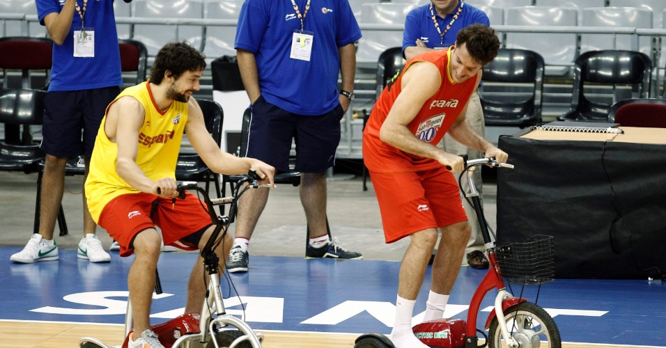 Sergio Llull (e) e Rudy Fernandez, da seleção espanhola de basquete, aproveitam um intervalo dos treinos e brincam com triciclos elétricos 
