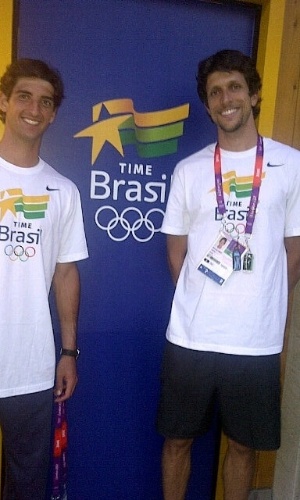 tenistas Marcelo Melo e Thomas Bellucci tirando foto em frente ao local aonde ficam os apartamentos da equipe brasileira nos Jogos Olímpicos