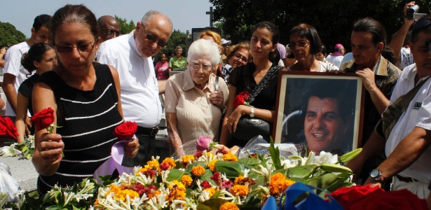 A mulher do líder da dissidência cubana Oswaldo Payá, que morreu no domingo (22) em um acidente de trânsito, coloca rosas no caixão antes do enterro, em Havana, na terça-feira (24) - Reuters
