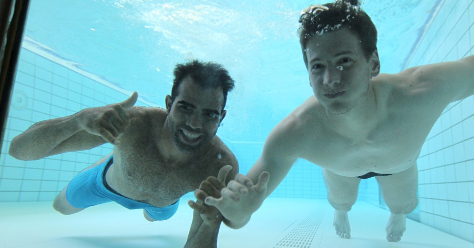 Sandro (esq.) e Neto posam para foto do fundo da piscina. Jogadores da seleção se preparam para a estreia na quinta-feira, contra o Egito