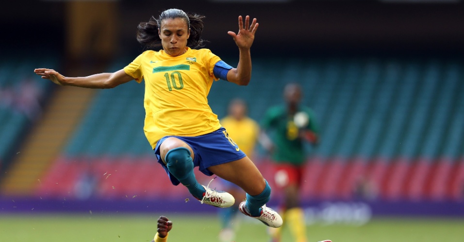 Marta salta para fugir da marcação da rival da seleção de Camarões
