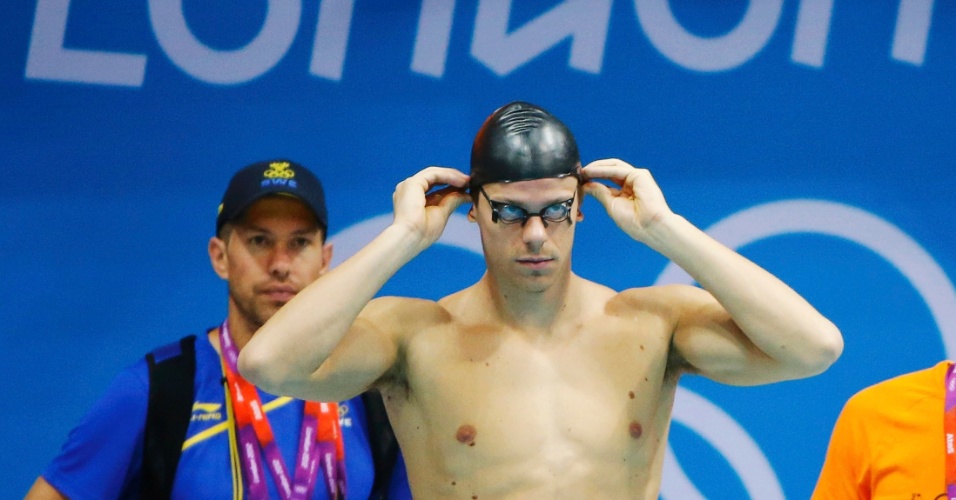 O nadador brasileiro Cesar Cielo arruma touca durante treino no centro aquático em Londres nesta quarta-feira (25)