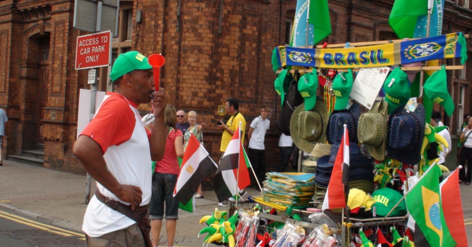 Ambulantes vendem produtos para a torcida brasileira antes da estreia na Olimpíada