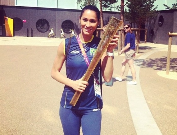 Jogadora de vôlei Jaqueline posa com uma réplica da tocha olímpica de Londres