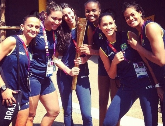 Jogadoras da equipe de vôlei feminino posam com a tocha dos Jogos Olímpicos de Londres