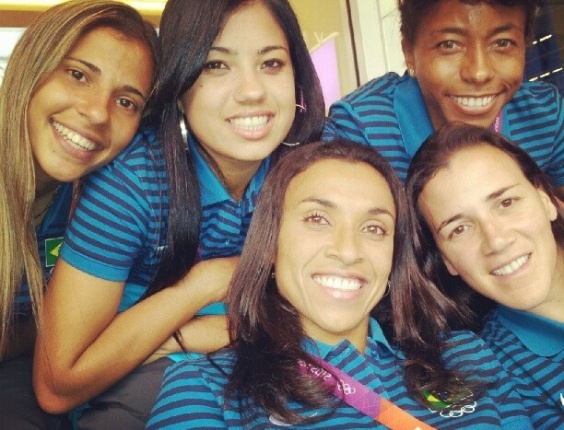 Jogadoras da seleção feminina de futebol acompanham a estréia da equipe masculina do Brasil contra o Egito
