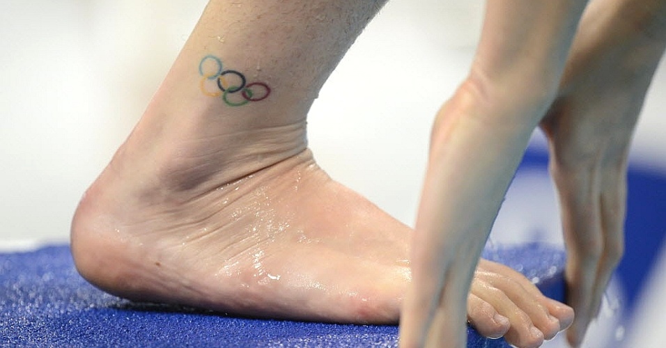 Nadadora Camille Muffat exibe tatuagem delicada no pé, ao tomar impulso e se jogar na piscina