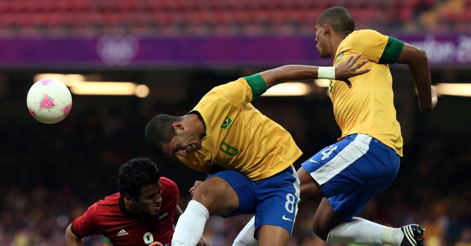 O egípcio Marwan Mohsen (e) disputa a bola com os brasileiros Rômulo (c) e Juan no duelo Brasil x Egito