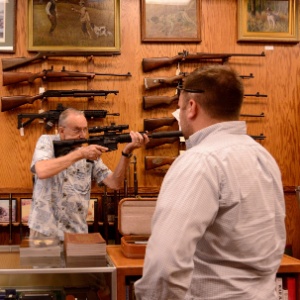 Vendedor mostra como se opera um rifle Colt AR-15 em uma loja de armas de Atlanta, Georgia - Erik S. Lesser/EFE