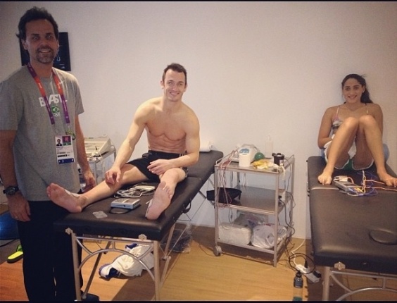 Diego Hypólito tira foto da sala de fisioterapia ao lado de Daynara de Paula, atleta da equipe de natação