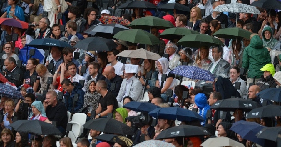 Espectadores se protegem da chuva no Estádio Olímpico de Londres