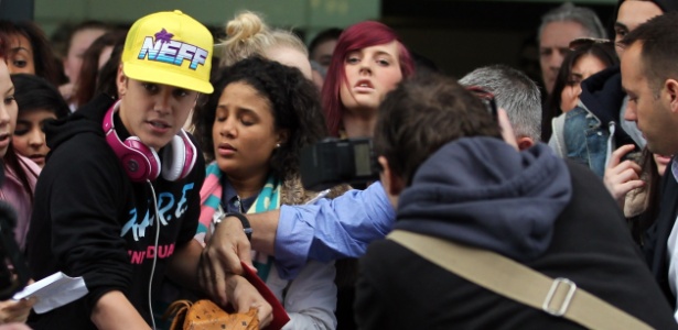 Justin Bieber é cercado por fãs ao desembarcar no aeroporto de Heathrow, em Londres (23/3/12)