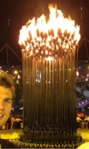Tiago Splitter, da equipe de basquete masculino, tira foto ao lado da tocha olímpica