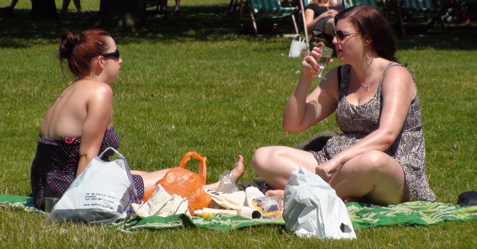 Amigas fazem piquenique no gramado do Hyde Park, centro de Londres. Muitos londrinos aproveitam o sol para se queimar durante a hora do almoço