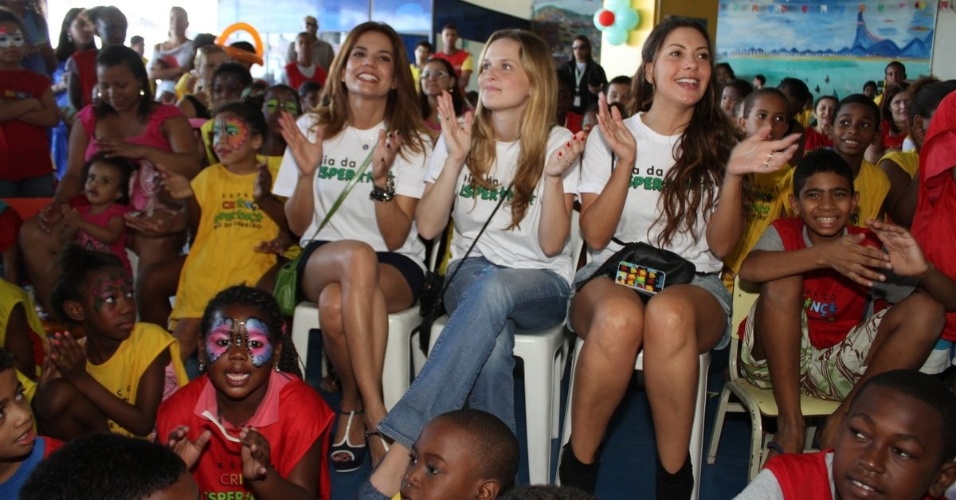 As atrizes Nívea Stelmann, Fernanda Rodrigues e Fabíola Nascimento (da esq para dir) participam de evento com crianças no Morro do Cantagalo, no Rio de Janeiro (28/7/12)