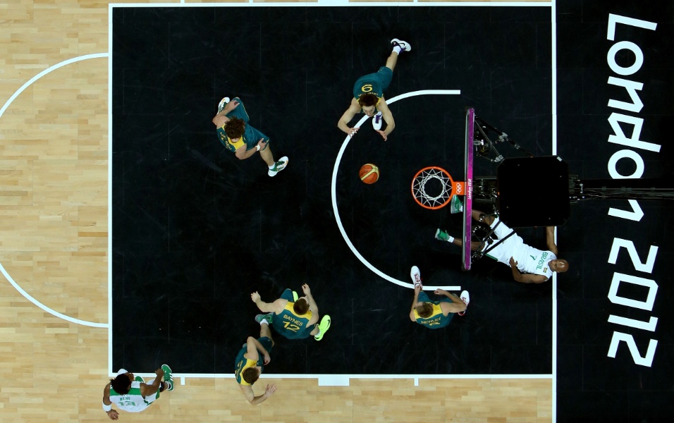 Brasileiro Larry Taylor fica caído no chão após sofrer uma falta no jogo contra a Austrália pelo basquete masculino olímpico