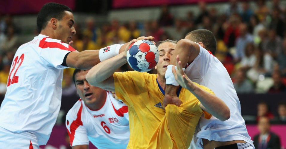 Jogadores da Tunísia seguram Kim Ekdahl du Rietz, da Suécia, em jogo disputado neste domingo (29/07)